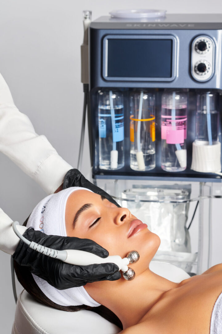 A woman getting her face cleaned by an esthetician.